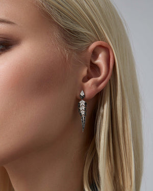 Close-up of black and white diamond pavé and feather-inspired detailing on tail feather jewellery earrings
