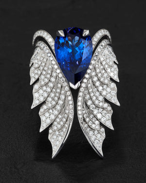 Close-up of pear-shaped tanzanite and sparkling white diamond pavé detailing on cocktail ring