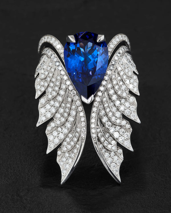 Close-up of pear-shaped tanzanite and sparkling white diamond pavé detailing on cocktail ring