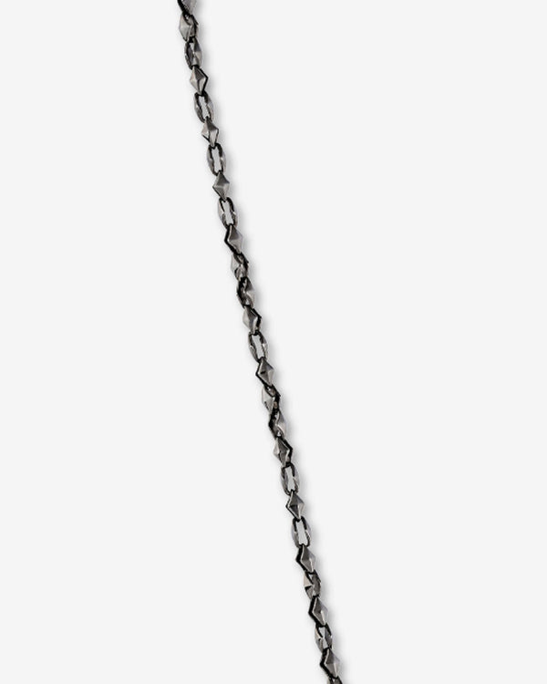 Close-up of the thorn dagger motif and polished black rhodium-plated sterling silver finish on Stephen Webster Thorn Dagger Pendant