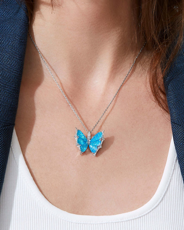 Close-up of model wearing Fly By Night butterfly Black Opalescent Crystal Haze pendant necklace in 18k white gold