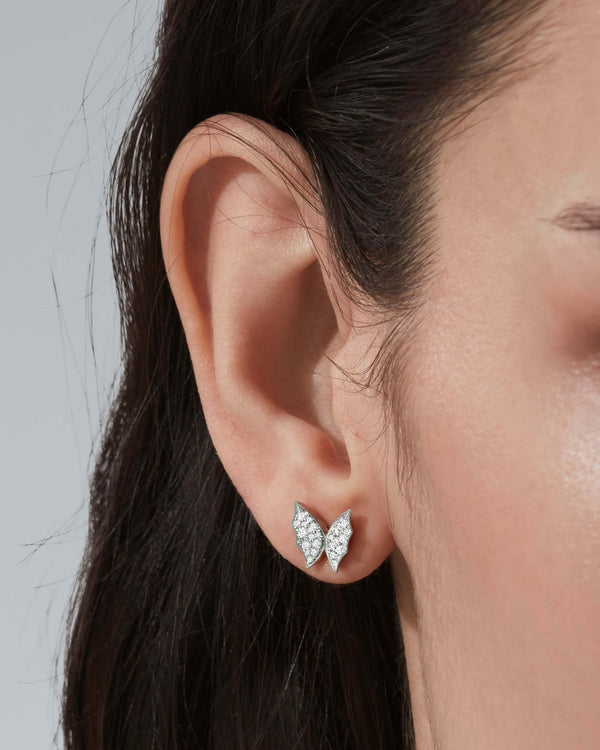 Model wearing Fly By Night butterfly pavé stud earrings in 18k white gold with diamonds