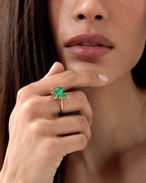 Model wearing Fly By Night mini butterfly cocktail ring in 18k yellow gold with green gemstones
