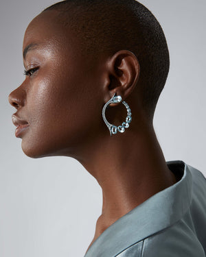 Forbidden Fruit Earrings in blue titanium worn on ear, luxury fine jewellery styling