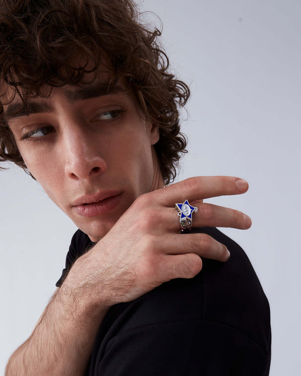 Model wearing Stephen Webster × Machine Gun Kelly Gossip Ring Edition Eight — silver ring with electric-blue enamel star