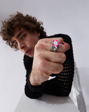 Male model wearing Stephen Webster × Machine Gun Kelly Gossip Ring Edition Eight — silver ring with pink enamel star