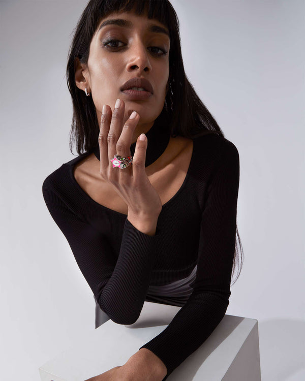 Model wearing Stephen Webster × Machine Gun Kelly Gossip Ring Edition Eight — silver ring with pink enamel star
