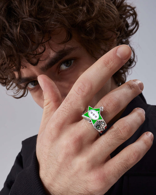 Model wearing Stephen Webster × Machine Gun Kelly Gossip Ring Edition Seven — silver ring with neon-green enamel star