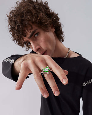 Model wearing Stephen Webster × Machine Gun Kelly Gossip Ring Edition Seven — silver ring with neon-green enamel star