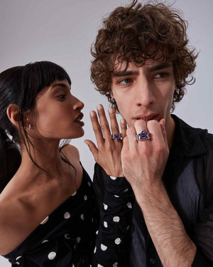 Model couple wearing Stephen Webster × Machine Gun Kelly Gossip Rings — silver ring with deep-purple enamel star