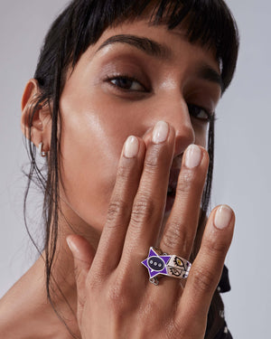 Model wearing Stephen Webster × Machine Gun Kelly Gossip Ring — silver ring with deep-purple enamel star