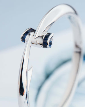 Close-up detail of square blue sapphires on Stephen Webster Hammerhead Bangle in 18ct white gold, premium gemstone luxury jewellery