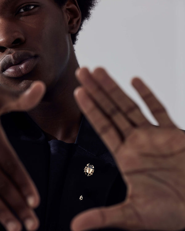 Suit jacket with Stephen Webster Jitterbug Toro Beetle lapel pin — yellow-gold beetle pin with black diamonds and spinel