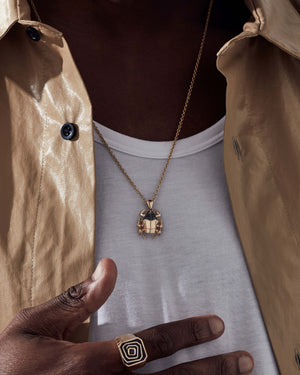 “Model wearing Stephen Webster Jitterbug Toro Beetle pendant — 18 ct yellow-gold insect pendant with diamond pavé and spinel detail”