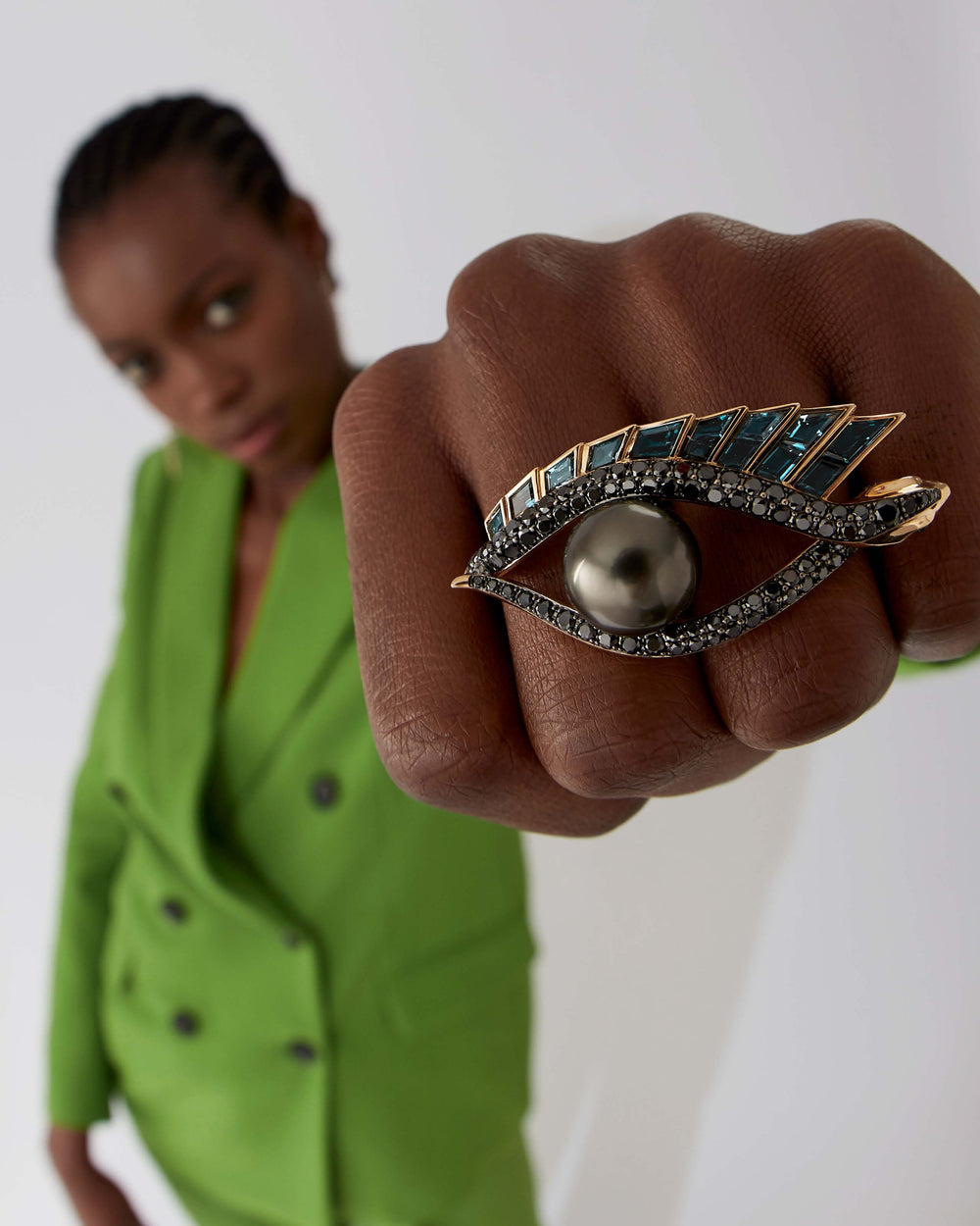 Love On The Nile cocktail ring in 18 ct yellow gold with central Tahitian black pearl, black diamonds, blue topaz baguettes and green tsavorites — front view