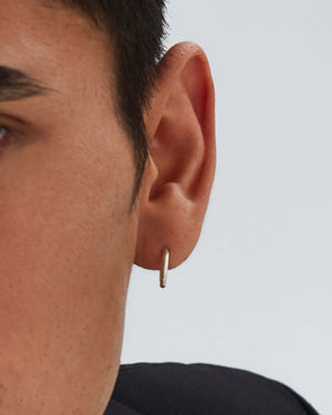 Macro close-up of Stephen Webster Thorn Sleeper earring on model’s ear showing thorn motif and polished finish