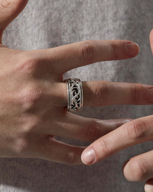 Macro close-up of Stephen Webster Thorn Carved Rotating Ring on model’s finger showing polished silver and carved details