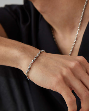 Macro close-up of Stephen Webster Thorn Classic 7 mm link silver bracelet on skin, showing texture and finish