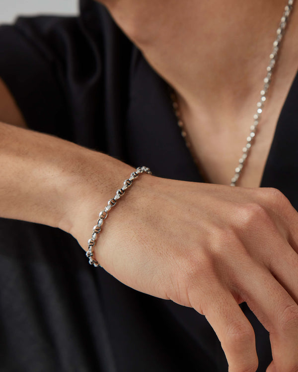 Macro close-up of Stephen Webster Thorn Classic 7 mm link silver bracelet on skin, showing texture and finish