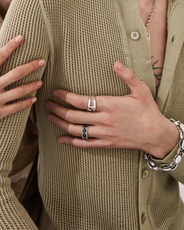 Male model wearing Stephen Webster Classic Black Sapphire Link Spinning Band styled with other men’s jewellery pieces