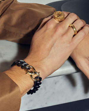 Male model wearing Stephen Webster Thorn Addiction gold clasp styled with other men’s jewellery pieces