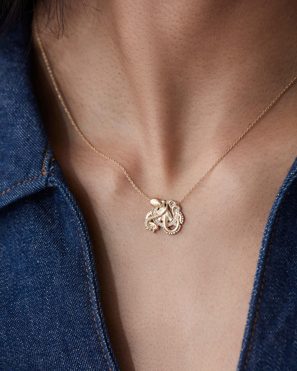 Model close up wearing Stephen Webster O is for Octopus initial necklace in 18ct yellow gold with diamonds, personalised luxury jewellery gift for her