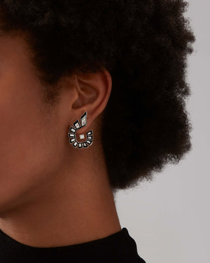 Model close up wearing Stephen Webster Dynamite Enamel Hoop Earrings in 18ct white gold with white diamonds and black enamel, contemporary luxury jewellery gift styling