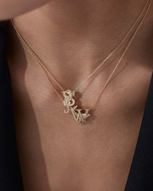 Model close up wearing Stephen Webster W is for Whale initial necklace in 18ct yellow gold with diamonds, personalised luxury jewellery gift for her