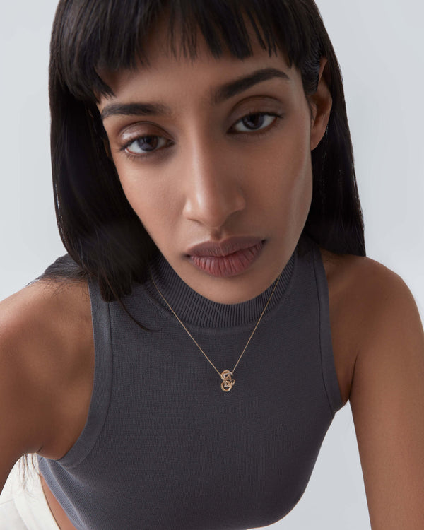 Model wearing Stephen Webster E is for Electric Eel initial necklace in 18ct yellow gold with diamonds, personalised luxury gift for her