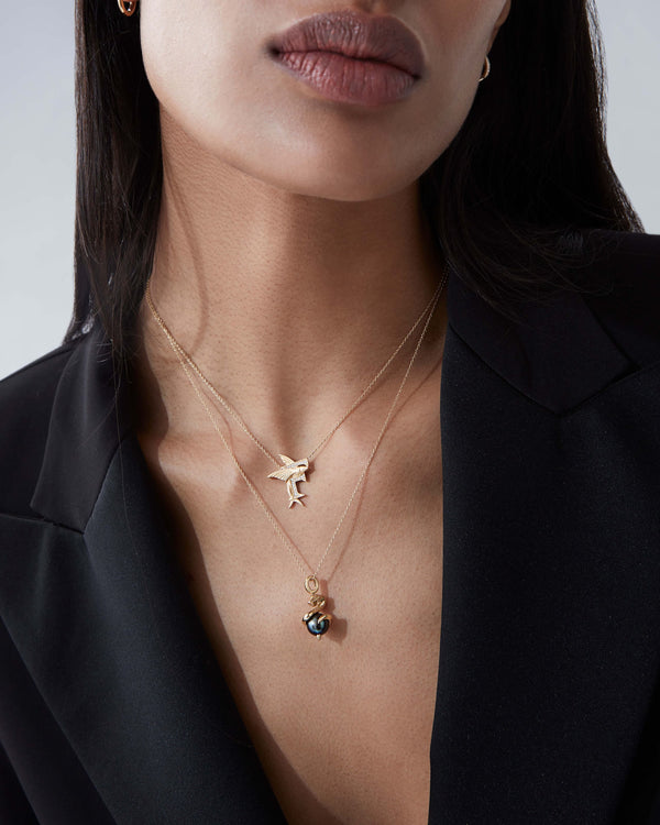 Model wearing Stephen Webster F is for Flying Fish initial necklace in 18ct yellow gold with diamonds, personalised luxury gift for her