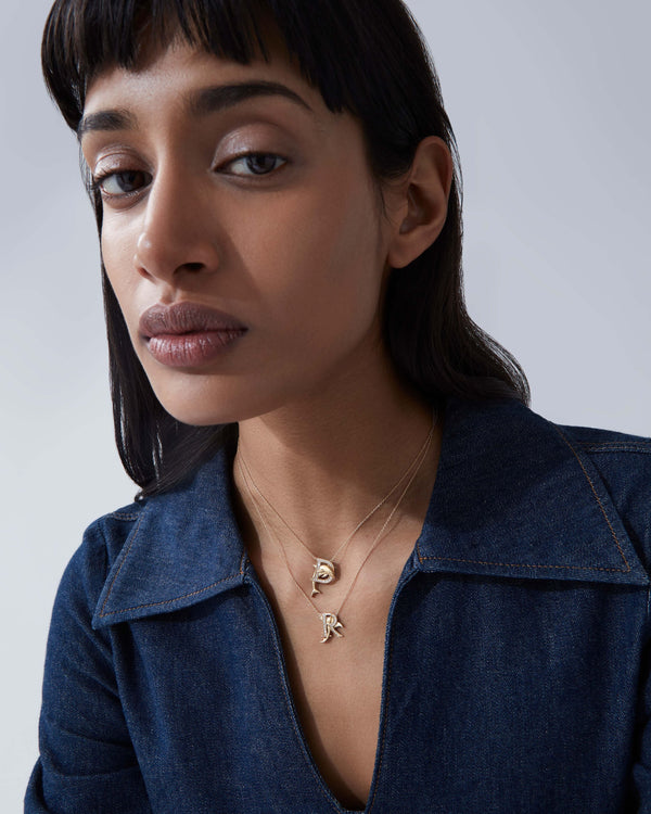 Model wearing Stephen Webster R is for Ray initial necklace in 18ct yellow gold with diamonds, personalised luxury jewellery gift for her