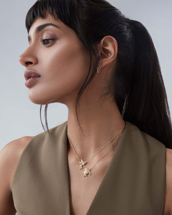 Model wearing Stephen Webster T is for Turtle initial necklace in 18ct yellow gold with diamonds, personalised luxury jewellery gift for her