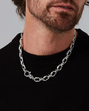 Lifestyle image of model wearing Stephen Webster Thorn Entwined 12 mm link sterling silver chain with modern menswear