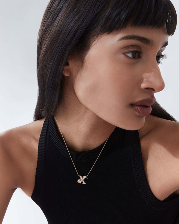 Model wearing Stephen Webster X is for X-Ray Fish initial necklace in 18ct yellow gold with diamonds, personalised luxury jewellery gift for her