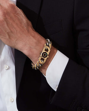 Model wearing Stephen Webster Rat Race clasp in 18k yellow gold & sterling silver with black onyx, red garnet, emerald and mother of pearl back plate