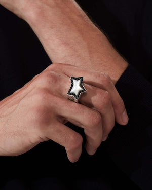 Close up of model wearing Stephen Webster Rockstar star-shaped ring in sterling silver with central white mother of pearl star and pavé diamonds