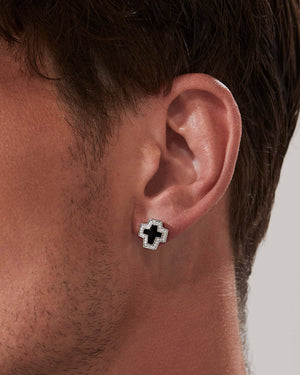 Model wearing Stephen Webster cross-shaped black onyx earring on neutral background — Sex & Drugs & Rock & Roll collection