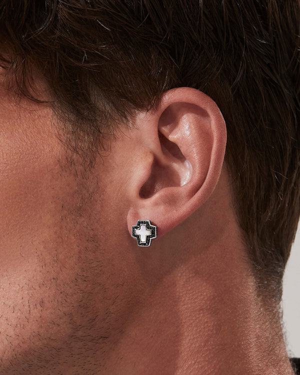 Model wearing Stephen Webster cross-shaped white mother of pearl earring on neutral background — Sex & Drugs & Rock & Roll collection