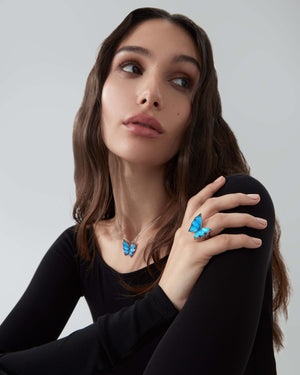 Model wearing Stephen Webster Black Opalescent Crystal Haze butterfly pendant and ring — 18 ct white gold fine jewellery