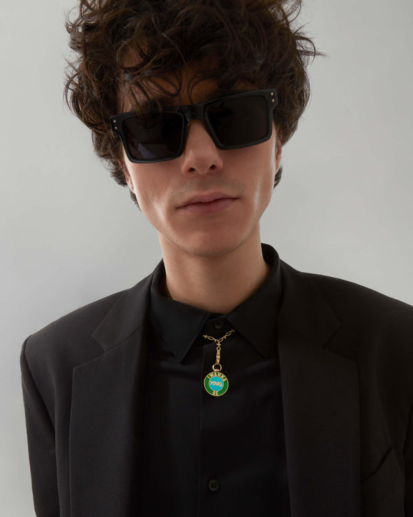 Model wearing Stephen Webster Bonus Track gold pendant necklace — showing pendant size, enamel detail and gold finish