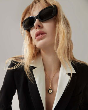 Model wearing the Stephen Webster Coffee Pot gold pendant necklace — showing pendant size, gold chain and black enamel detail