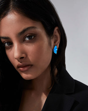 Model wearing Stephen Webster Black Opalescent Crystal Haze blue butterfly cuff earrings — 18 ct white gold statement earrings