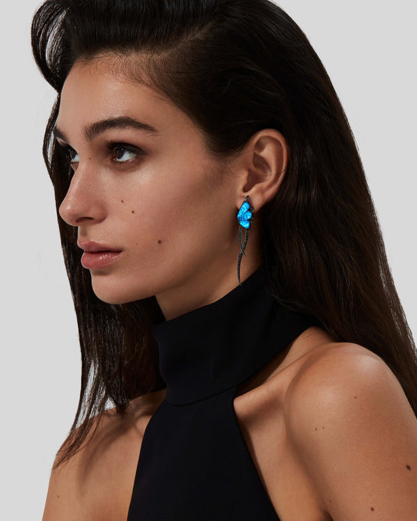 Model wearing Stephen Webster Crystal Haze blue butterfly drop earrings — 18 ct white gold statement earrings