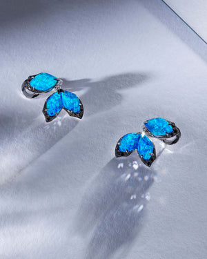 Luxury lifestyle flatlay of Stephen Webster Crystal Haze Chance black opal chance earrings styled with couture accessories and rich textures for editorial appeal