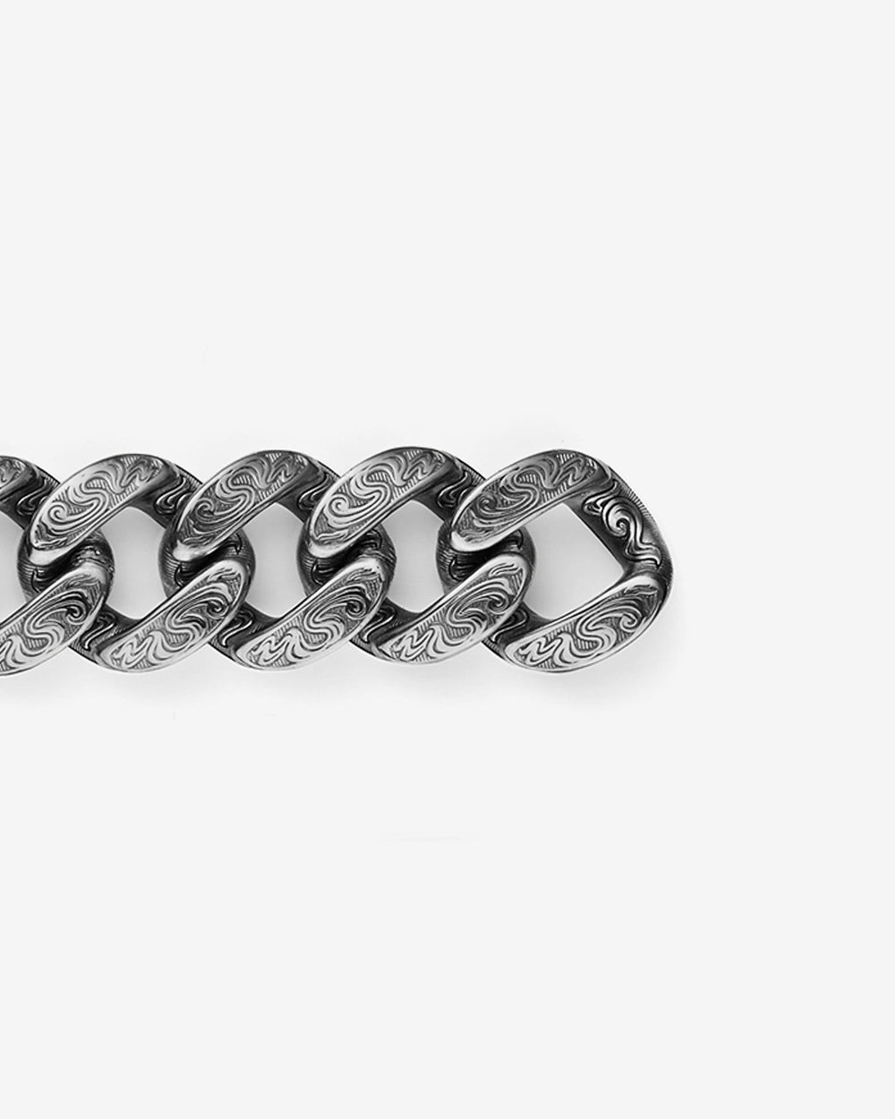 Close-up detail of Stephen Webster Cuban bracelet in silver — engraved smoke-pattern links and polished metal texture visible