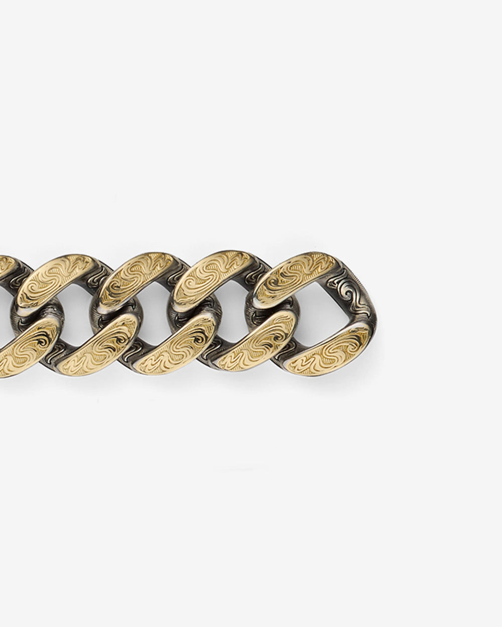 Close-up detail of Stephen Webster Cuban bracelet in silver & yellow gold — engraved smoke-pattern links and polished metal texture visible