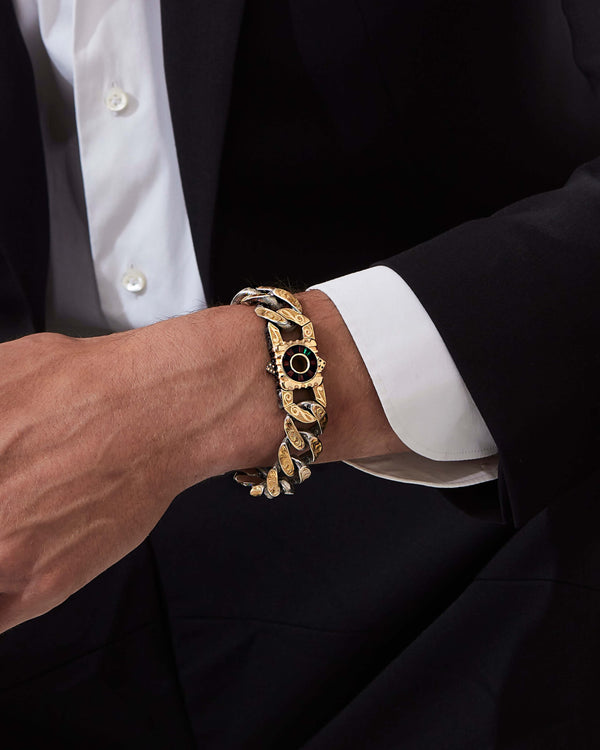 Model wearing Stephen Webster Cuban bracelet in silver & yellow gold with paired clasp — engraved smoke-pattern links and polished metal texture visible