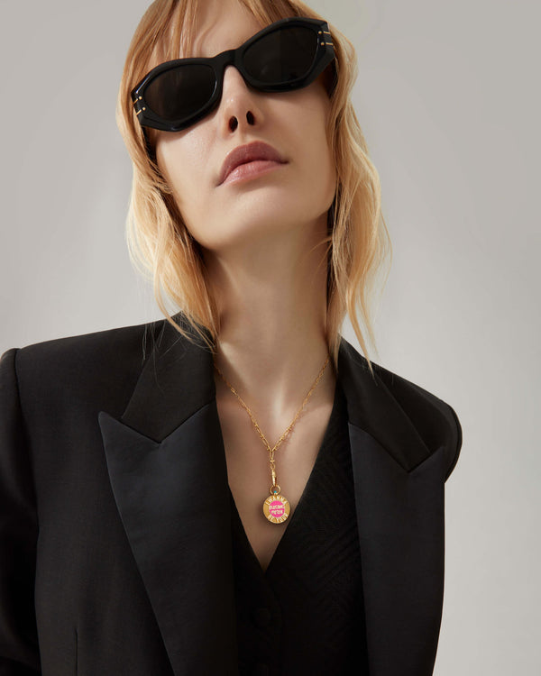 Stephen Webster Electric Meter pendant in 18 ct yellow gold worn as a necklace on the model, displaying the pink and turquoise enamel flip sides