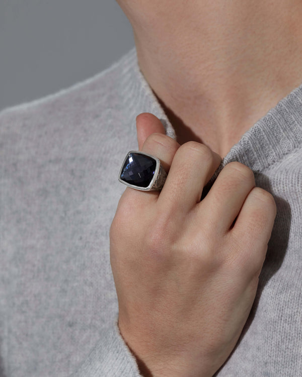 Close-up view of finger wearing the Embankment Fish ring — cushion-cut Hematite Crystal Haze gemstone, silver band detail and finish visible under light