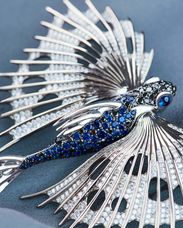 Close-up of Stephen Webster Flying Fish brooch highlighting deep blue sapphires, brilliant black diamonds and precision craftsmanship in titanium and white gold